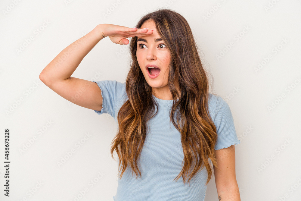 Young caucasian woman isolated on white background looking far away keeping hand on forehead.