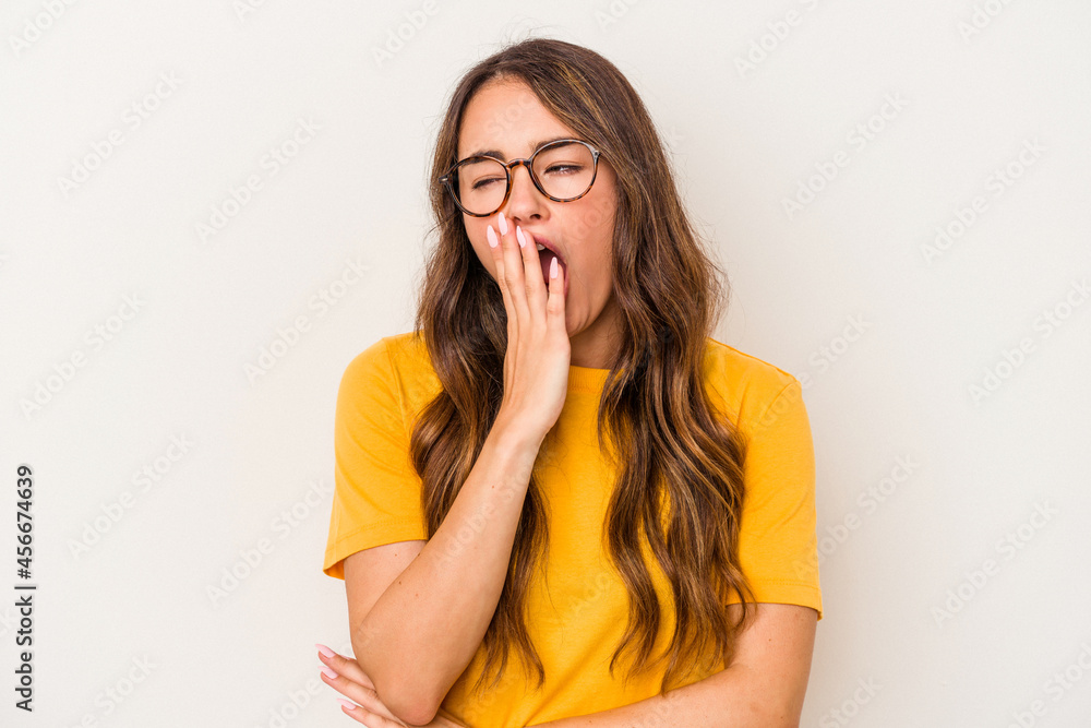Young caucasian woman isolated on white background yawning showing a tired gesture covering mouth with hand.