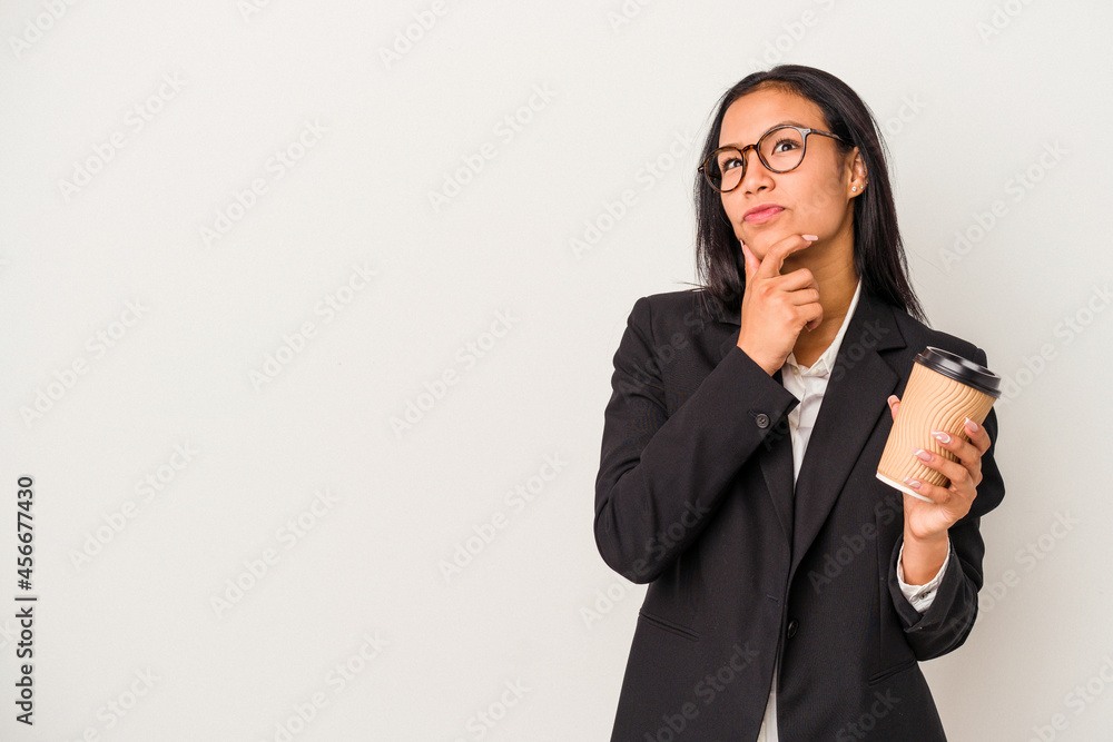 Young business latin woman holding a take away coffee isolated on white background looking sideways with doubtful and skeptical expression. Young business latin woman holding a take away coffee isolated on white background looking sideways with doubtful and skeptical expression.