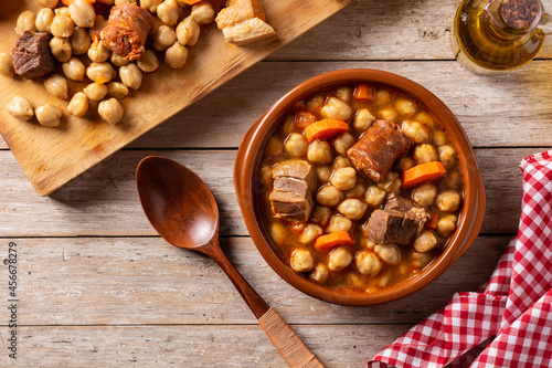 Traditional Spanish cocido madrileño on black background. Chickpea stew. photo