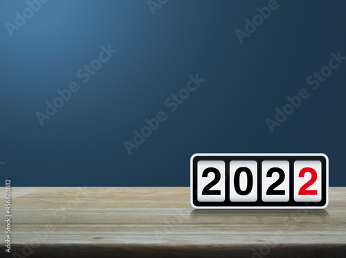 Retro flip clock with 2022 text on wooden table over light blue gradient background, Happy new year 2022 cover concept