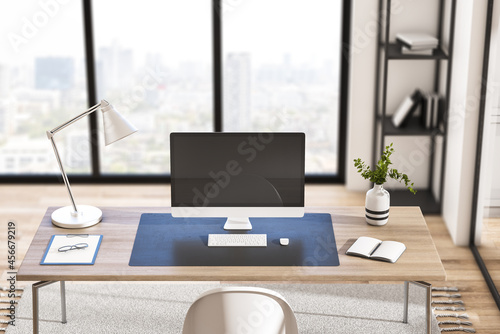 Close up of empty computer screen in creative modern daylight office studio interior with glass partition and window with city view  wooden flooring. 