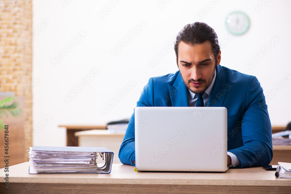 Young male employee and too many work in the office Young male employee and too many work in the office