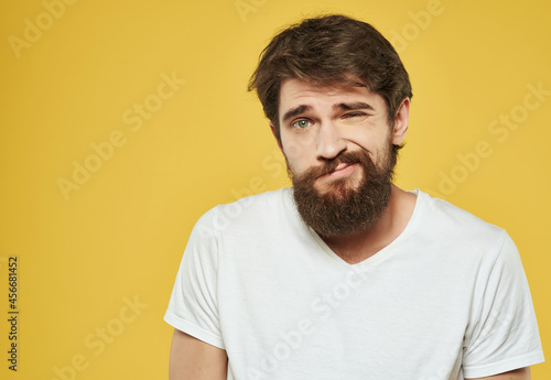 bearded man in a white t-shirt expressive look discontent close-up