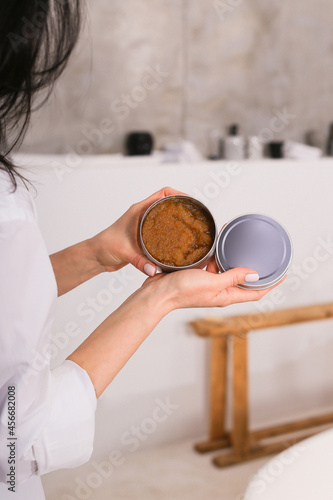 Woman holding botle or jar for spa cosmetics purpose in bathroom. Beauty blogger, salon therapy, minimalism concept, copyspace