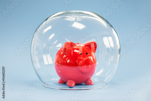 фотографія Protecting your savings, goldfish bowl covering a piggy bank