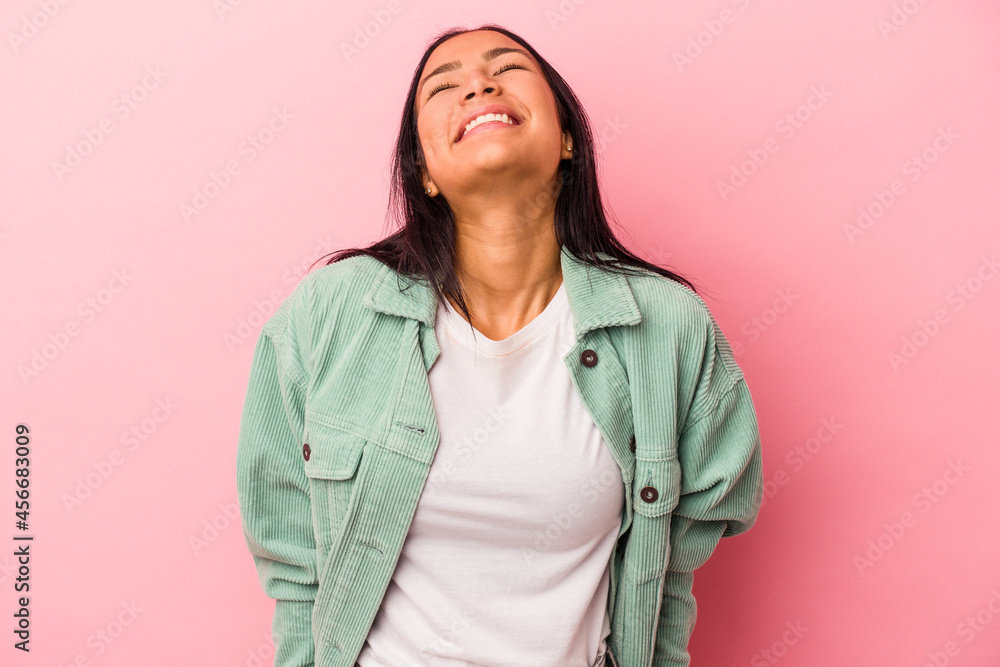 Young latin woman isolated on pink background laughs and closes eyes, feels relaxed and happy. Young latin woman isolated on pink background laughs and closes eyes, feels relaxed and happy.