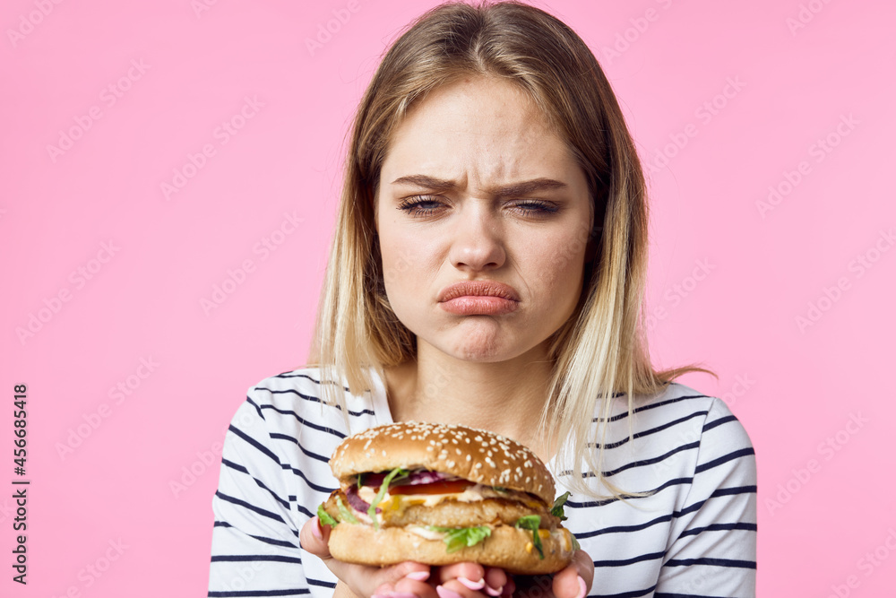 cute blonde girl in striped t-shirt hamburger close-up fast food lifestyle