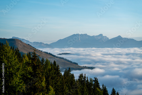 wonderful view in the morning with fog in the valley and blue sky on the mountains