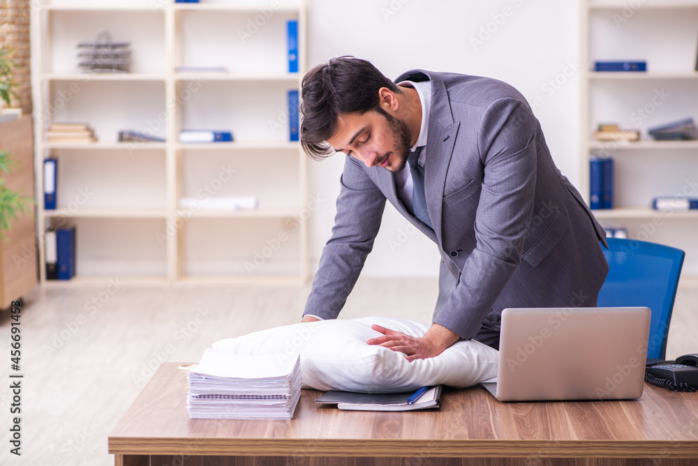 Young male employee in oversleeping concept Young male employee in oversleeping concept