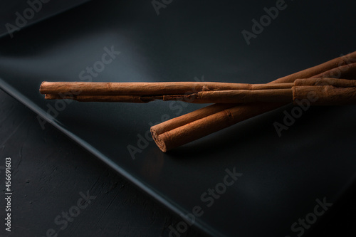 Close up of cinnamon sticks on black background.