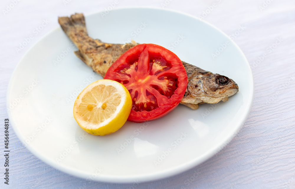Trout fish in a white plate on the table. Trout fish in a white plate on the table.
