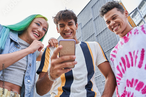 Girl and guys watching something on mobile phone photo