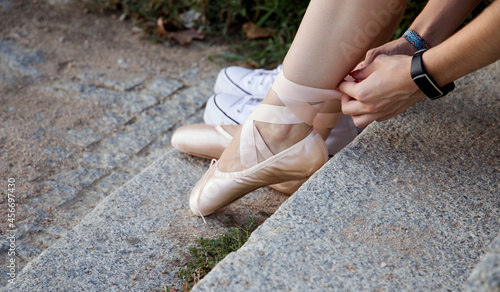 teenage girl tying her ballet shoes