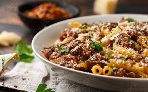 Photos Pasta alla Genovese on a white bowl with parmesan cheese