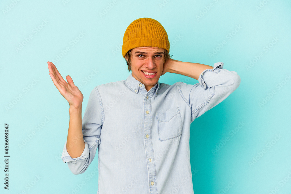 Young caucasian man with make up isolated on blue background screaming with rage. Young caucasian man with make up isolated on blue background screaming with rage.