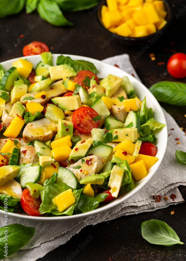 Tasty Chicken mango salad with avocado, cucumber, cherry tomatoes. Healthy food