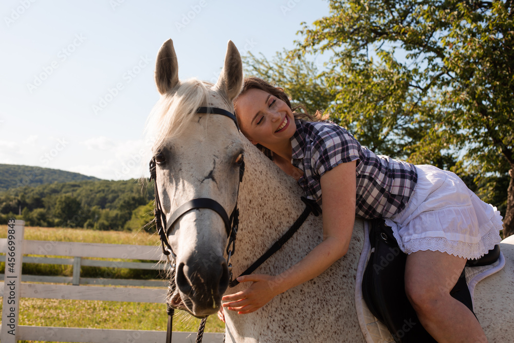 Obraz premium The young woman spends time with her favorite horse