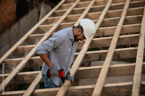 The young builder works on an unfinished roof
