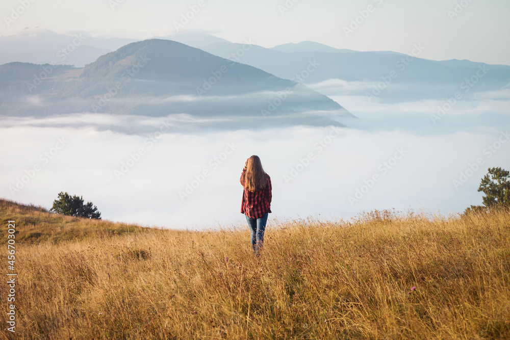 Young Girl in Foggy Autumn Landscape. Magical Morning Misty Carpathian Mountains
