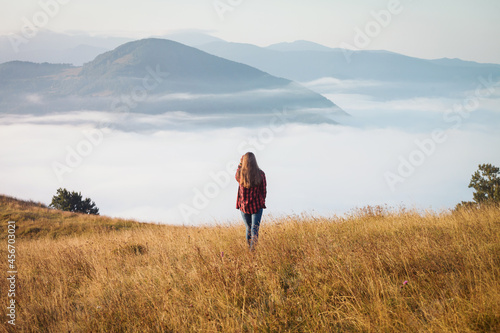 Young Girl in Foggy Autumn Landscape. Magical Morning Misty Carpathian Mountains 