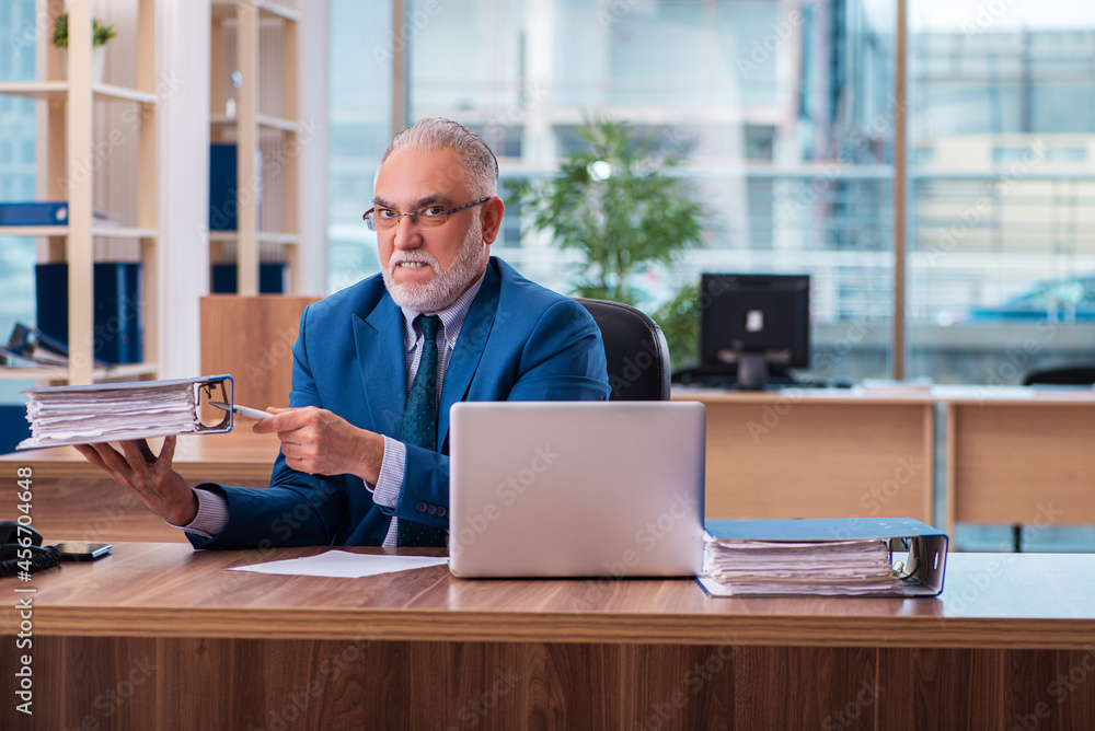 Old male employee working in the office Old male employee working in the office