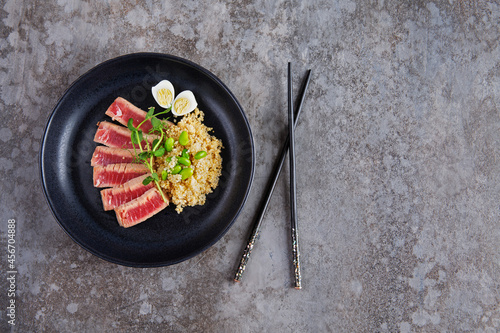 Fried pieces of tuna with kenoa and beans in a plate