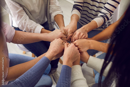 Group of ladies holding hands. Team of women ready to support each other sitting in a circle and holding their hands. Concepts of help, support, power, agreement and unity. Close up shot