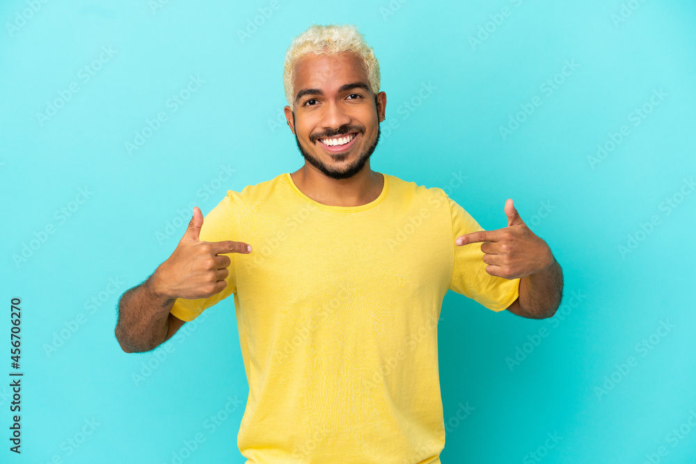 Young Colombian handsome man isolated on blue background proud and self-satisfied Young Colombian handsome man isolated on blue background proud and self-satisfied