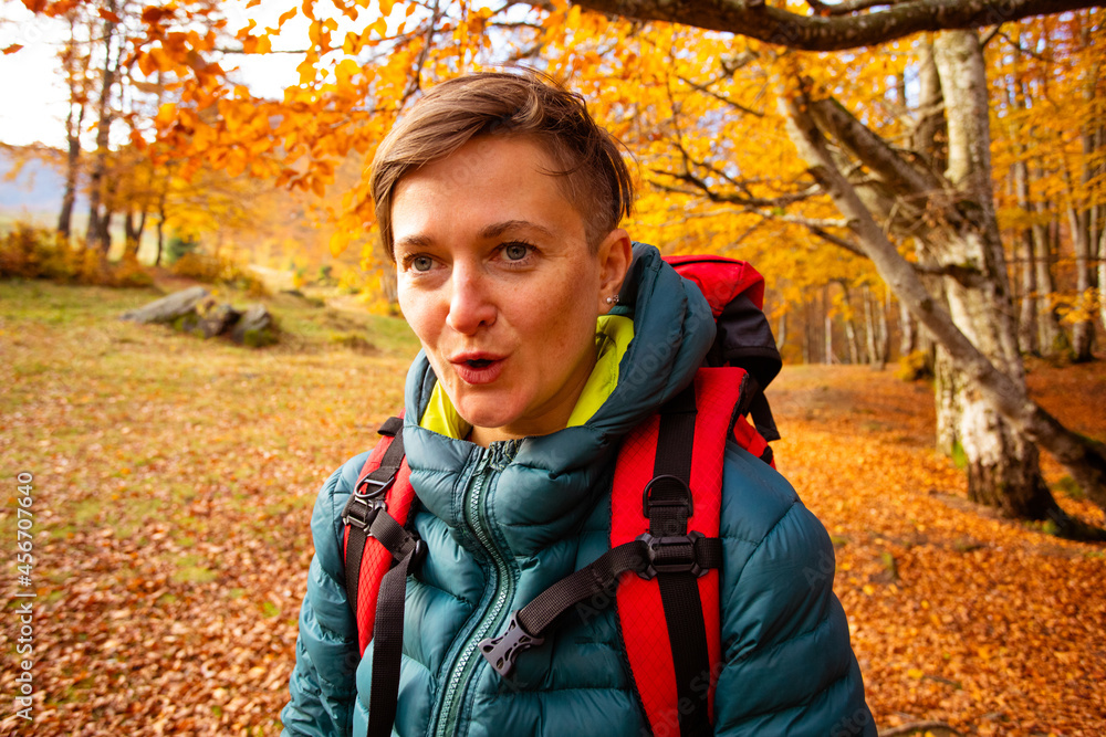 The woman hiker travels in the woods is looking around The woman hiker travels in the woods is looking around
