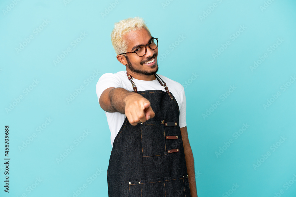 Restaurant Colombian waiter man isolated on blue background points finger at you with a confident expression