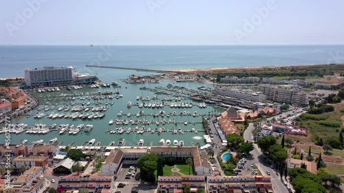 Aerial video of the tourist Portuguese town of Vilamoura, with views of the beaches and docks for luxury yachts, hotels and restaurants. Portugal, Algarve.