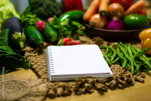 Agenda con verduras frescas en mesa de cocina. Dieta saludable, fondo de verduras. 