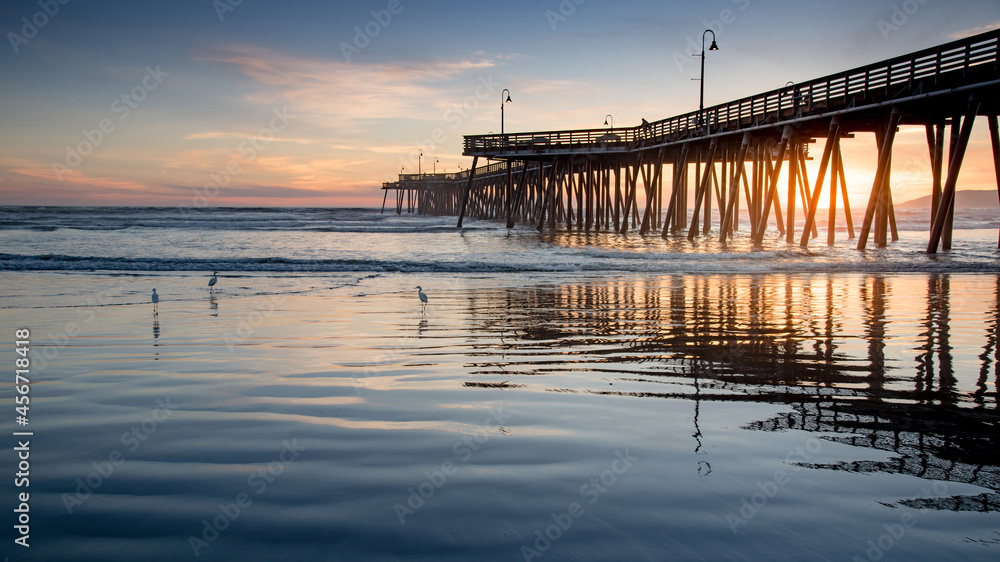 Beautiful sunset through the pedestrian bridge at Pismo beach pier, California, USA. Summer vacation concept