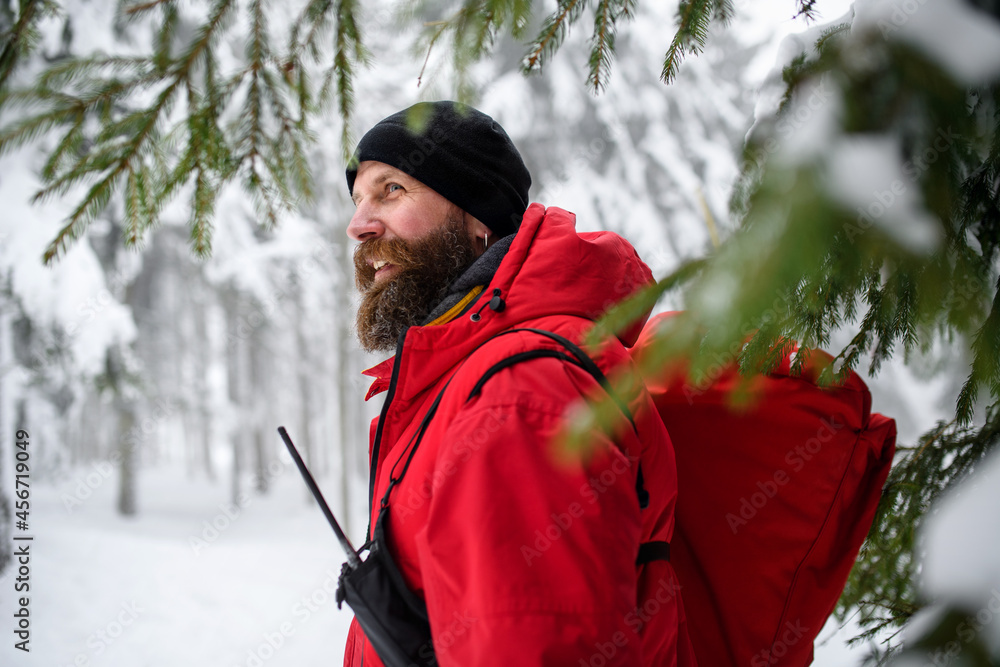Paramedic from mountain rescue service walking outdoors in winter in forest. Paramedic from mountain rescue service walking outdoors in winter in forest.
