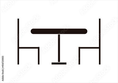 Icono negro de mesa y silla en fondo blanco.