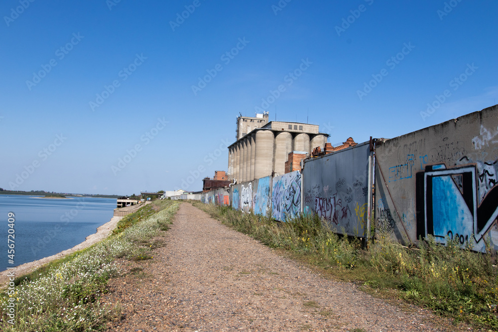 Bank of the river with pebbles on a sunny autumn day. Embankment of the Tom river Bank of the river with pebbles on a sunny autumn day. Embankment of the Tom river