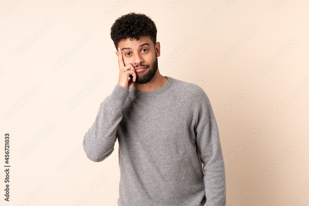 Young Moroccan man isolated on beige background thinking an idea Young Moroccan man isolated on beige background thinking an idea