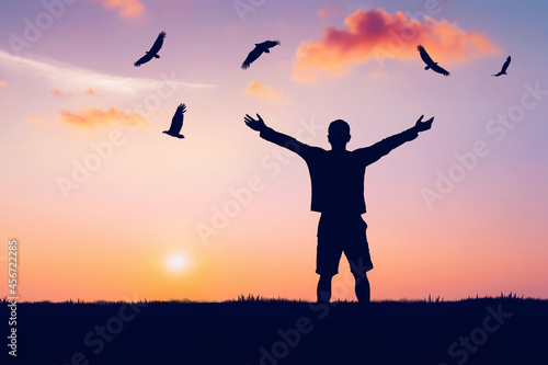 Photography Man rising hands and eagle birds flying on sunset sky at nature field abstract background