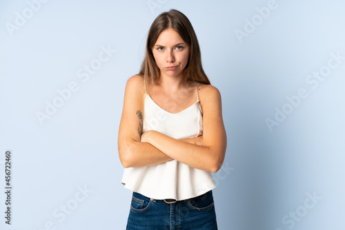 Young Lithuanian woman isolated on blue background with unhappy expression