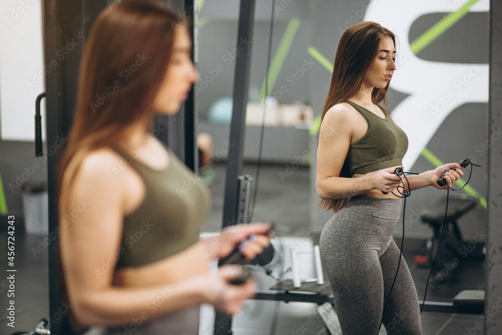 Girl at gym with jump rope in front of the mirror Girl at gym with jump rope in front of the mirror