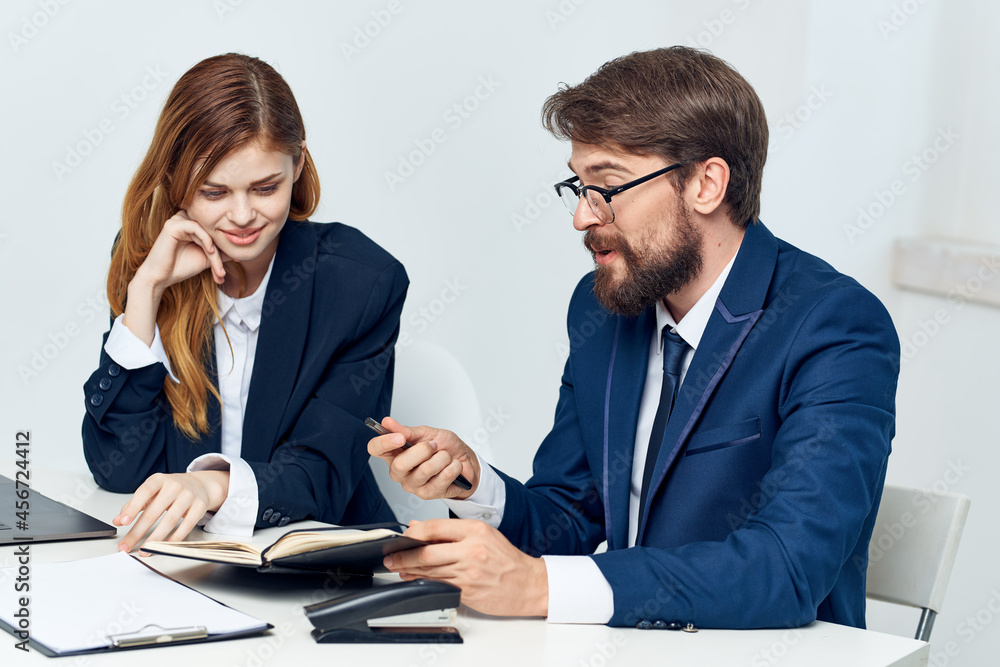 man and woman managers talking at the table in front of laptop team technology man and woman managers talking at the table in front of laptop team technology