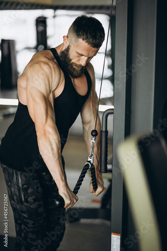 Handsome man bodybuilder doing workout at gym