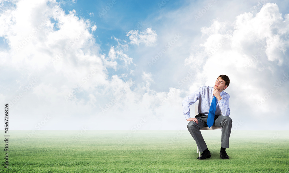 Young businessman sitting on an office chair Young businessman sitting on an office chair