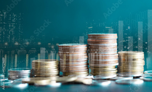 Double exposure of city and stack rows money coin with trading graph chart stock market. Value exchange and marketing of bank fund economic profit with growth. Finance investment and business concept.
