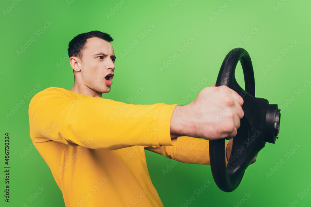 Portrait of mad careless driver guy hold steering wheel enjoy ride on green background Portrait of mad careless driver guy hold steering wheel enjoy ride on green background