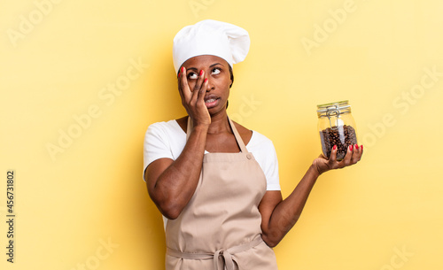 black afro chef woman feeling bored, frustrated and sleepy after a tiresome, dull and tedious task, holding face with hand. coffee beans concept