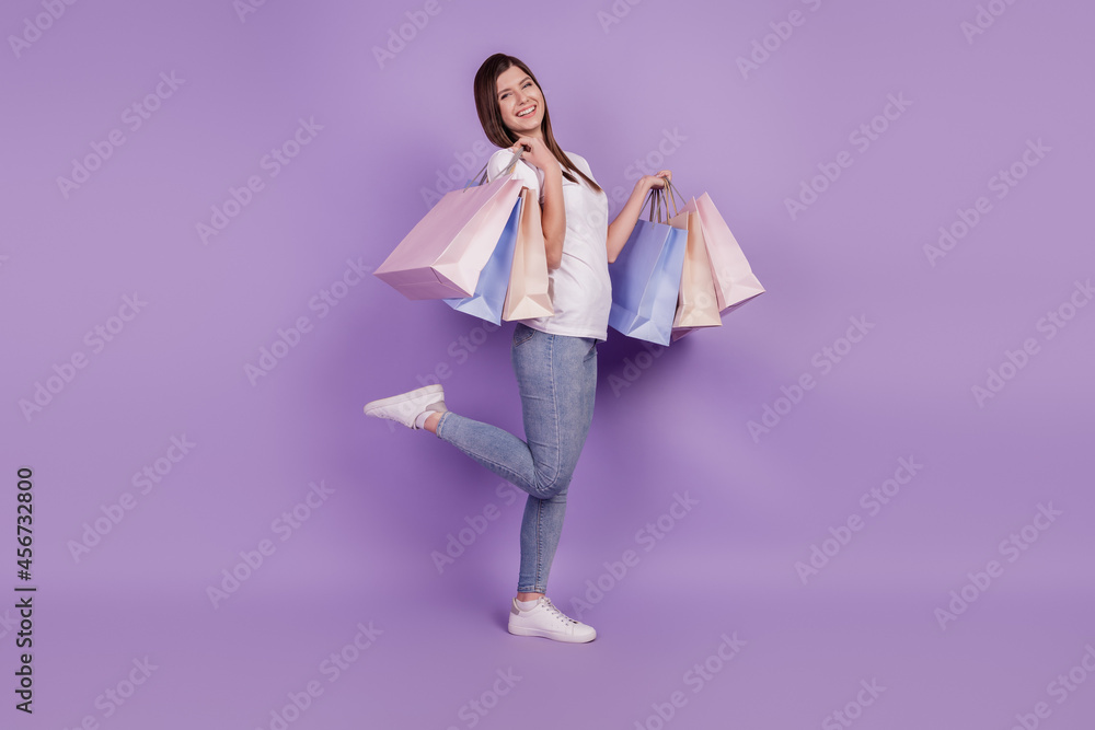 Photo of good mood lady carry shopping packs isolated violet background Photo of good mood lady carry shopping packs isolated violet background