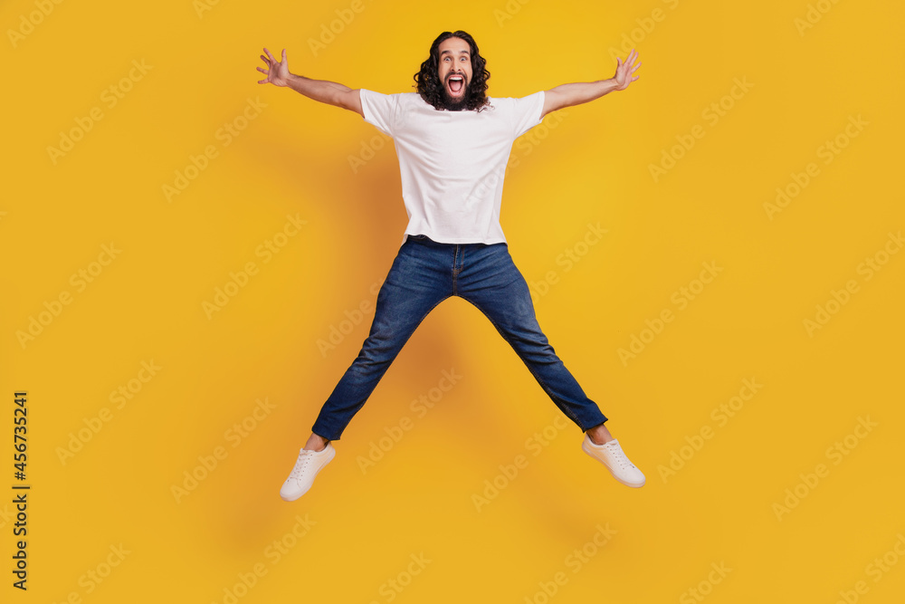 Portrait of funky sportive positive guy jump make star shape on yellow background