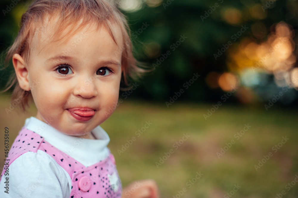 a little girl looking at the camera and amusingly showing her tongue a little girl looking at the camera and amusingly showing her tongue